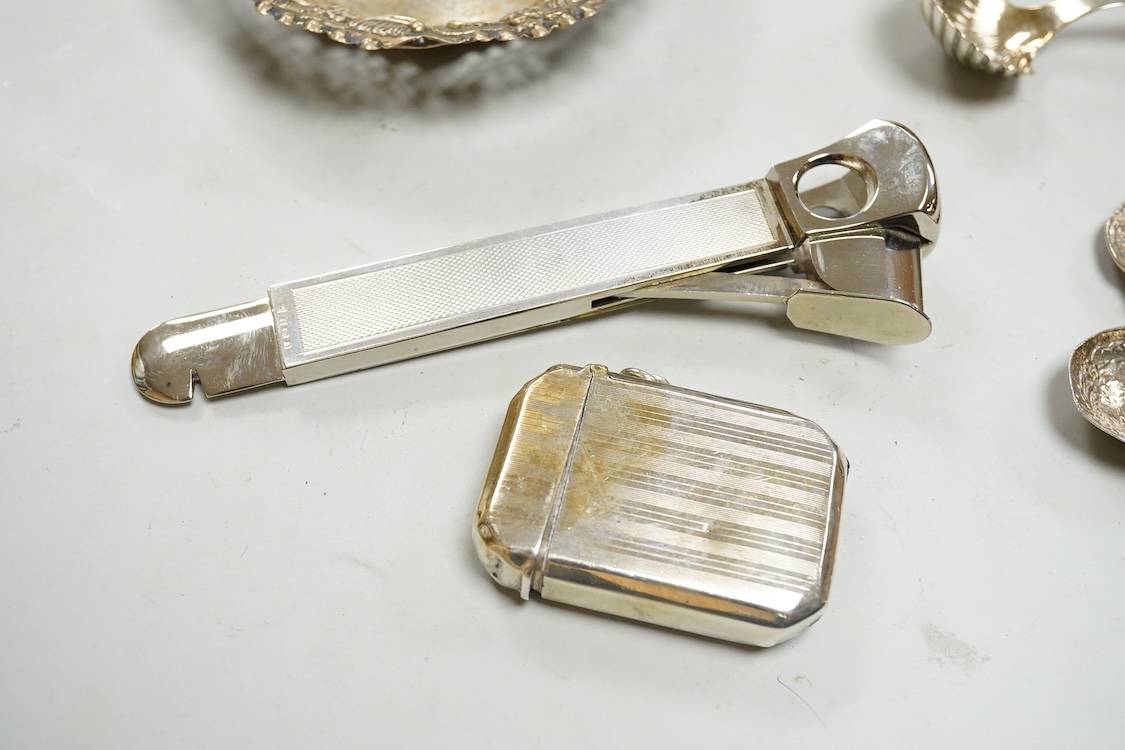 Small silver including two Edwardian caddy spoons, one German with import marks, a George V vesta case, a late Victorian pierced bonbon dish and a modern mounted steel cigar cutter.